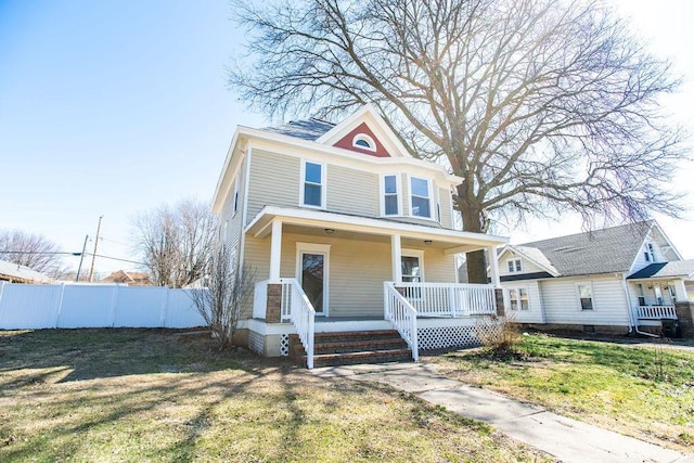 american foursquare style home with a porch, a front lawn, and fence