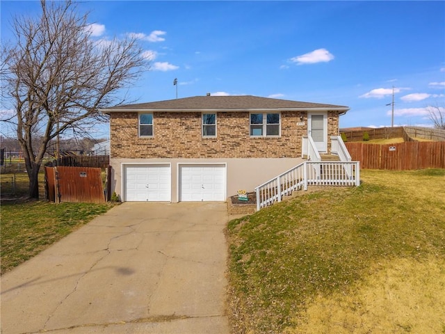 view of front of property with a front yard, fence, an attached garage, concrete driveway, and brick siding