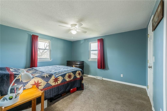 bedroom featuring carpet, visible vents, baseboards, ceiling fan, and a textured ceiling