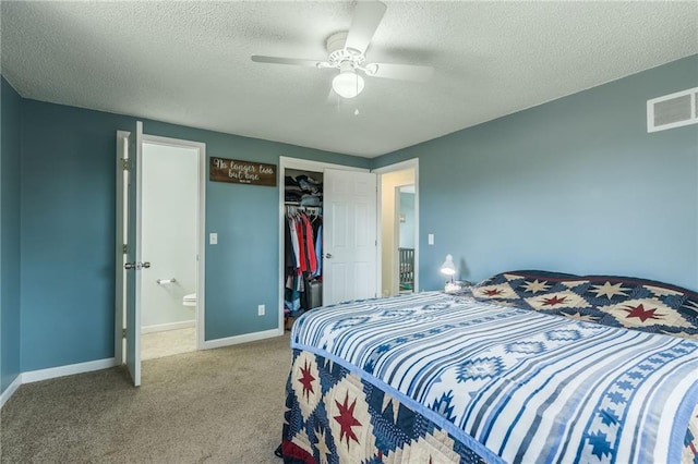 carpeted bedroom with a closet, visible vents, a textured ceiling, and baseboards