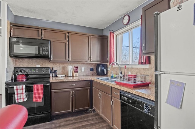 kitchen with dark wood-style flooring, backsplash, black appliances, and a sink