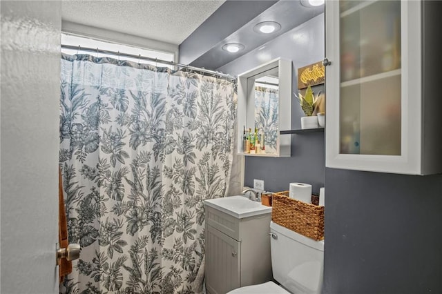 full bathroom with curtained shower, a textured ceiling, vanity, and toilet