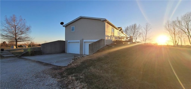 property exterior at dusk with concrete driveway and an attached garage