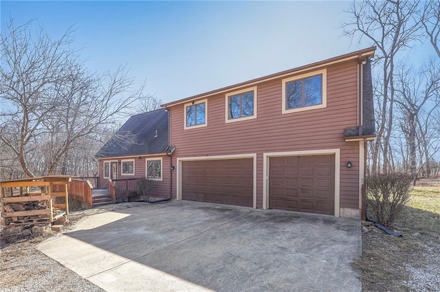 exterior space with a deck, concrete driveway, and an attached garage