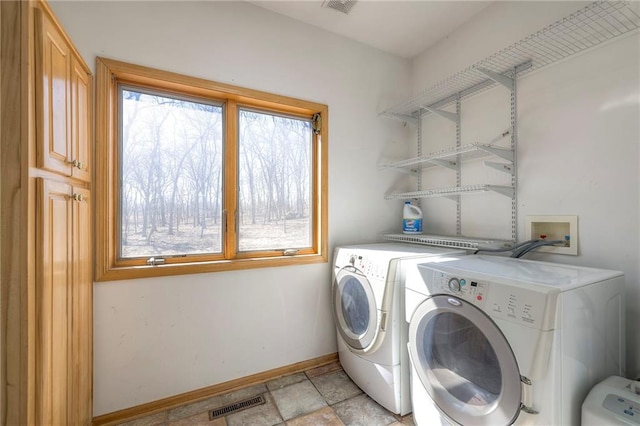 laundry room with laundry area, washing machine and dryer, visible vents, and baseboards