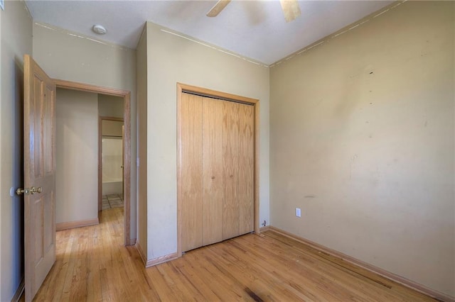 unfurnished bedroom featuring a closet, light wood-type flooring, and a ceiling fan