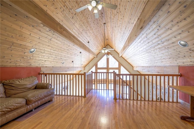 additional living space with wooden ceiling, vaulted ceiling with beams, wood finished floors, and ceiling fan