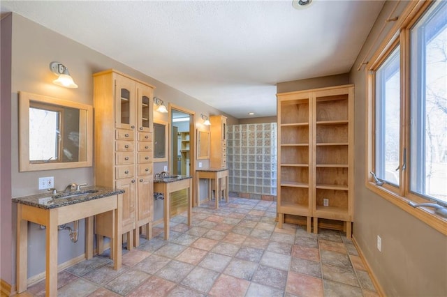 interior space featuring stone finish flooring, baseboards, and a healthy amount of sunlight