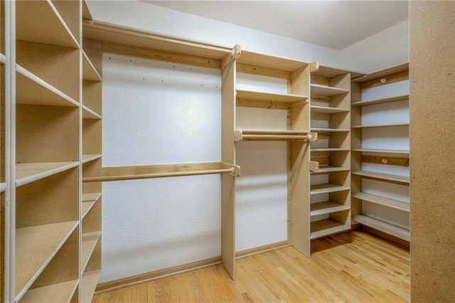 walk in closet with wood finished floors