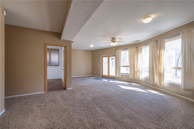 carpeted empty room featuring a textured ceiling, a ceiling fan, and baseboards