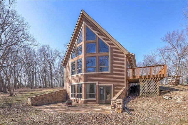 rear view of house featuring a deck and an outdoor fire pit