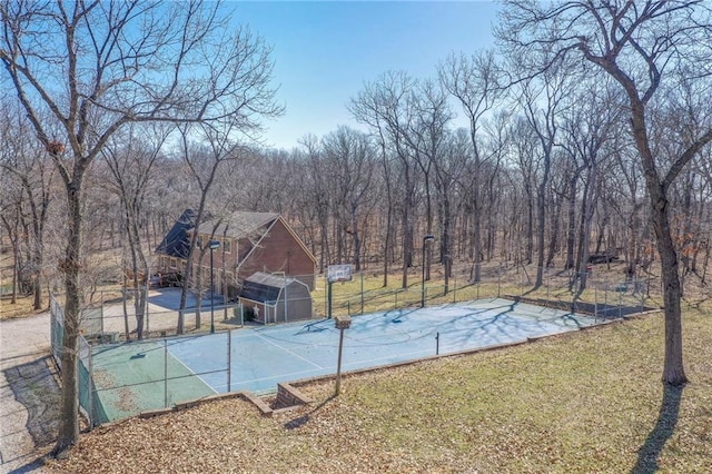 exterior space featuring a yard, a view of trees, an outdoor structure, and fence