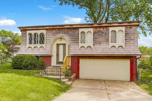 bi-level home with brick siding, fence, concrete driveway, a front yard, and mansard roof