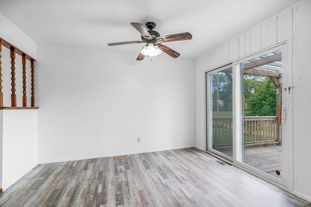 spare room with visible vents, baseboards, wood finished floors, and a ceiling fan