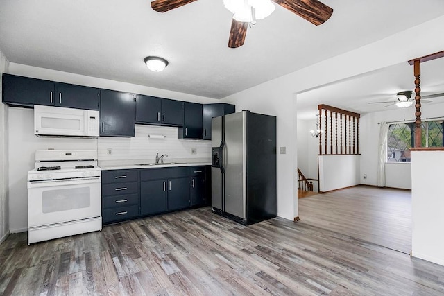 kitchen with white appliances, wood finished floors, light countertops, and a sink