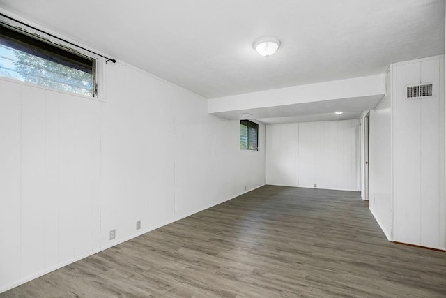 basement featuring visible vents, plenty of natural light, and wood finished floors