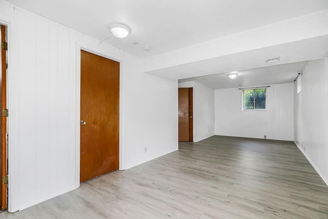 unfurnished room with wood finished floors and visible vents