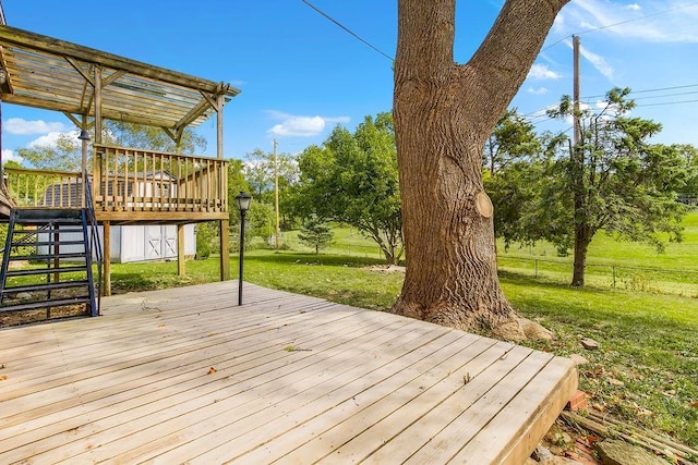 wooden terrace featuring stairway, a lawn, a pergola, and fence