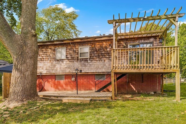 rear view of house with a deck, a lawn, a pergola, and brick siding