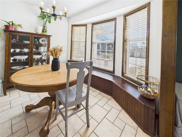 dining area with light tile patterned floors and an inviting chandelier