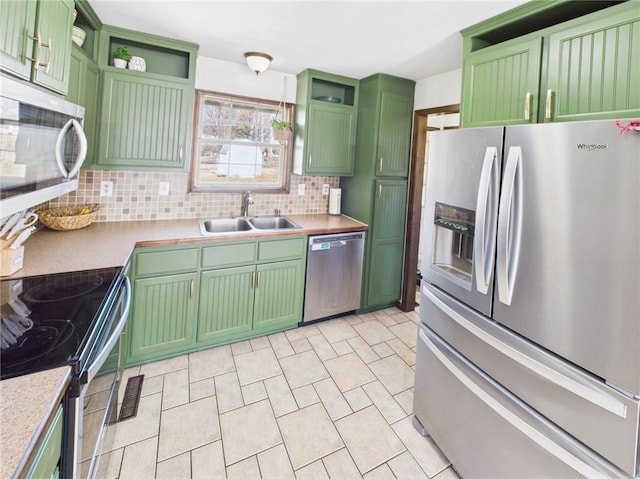 kitchen with a sink, open shelves, green cabinets, and stainless steel appliances