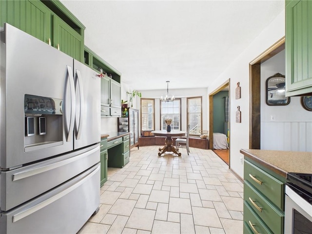 kitchen with green cabinets, stainless steel fridge with ice dispenser, hanging light fixtures, a notable chandelier, and range