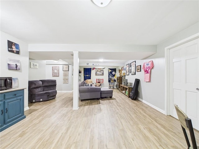 living room featuring baseboards and light wood-type flooring