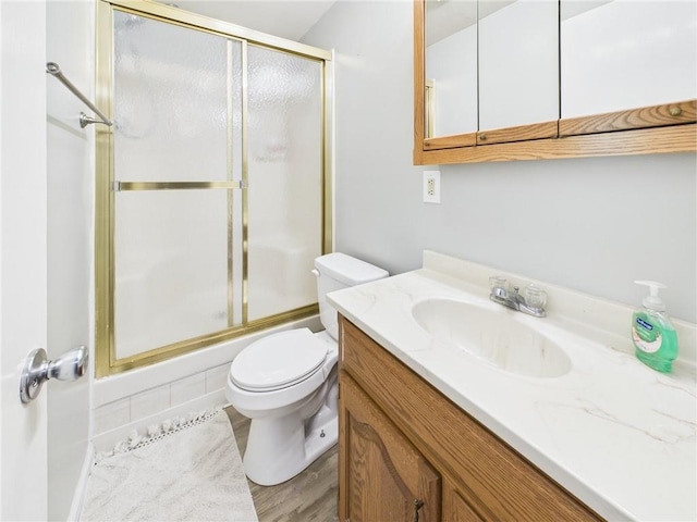 bathroom with an enclosed shower, toilet, and vanity