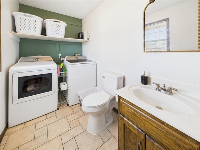 bathroom with tile patterned floors, washer and dryer, toilet, and vanity