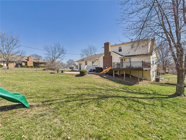 view of yard with a playground, a deck, and fence