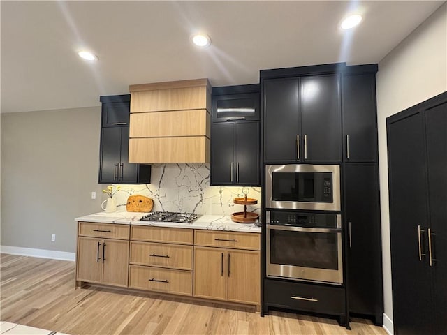 kitchen with light wood finished floors, decorative backsplash, recessed lighting, and appliances with stainless steel finishes