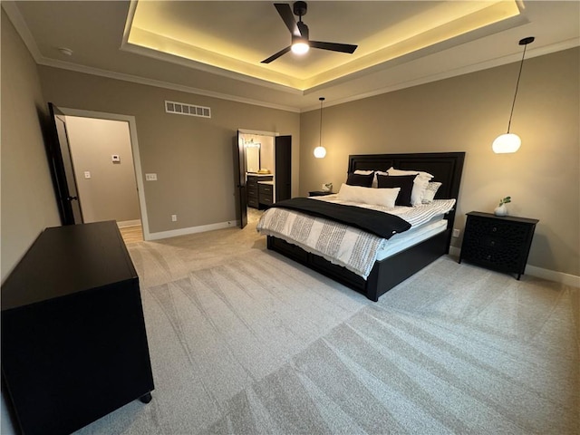 bedroom featuring light colored carpet, a tray ceiling, baseboards, and visible vents