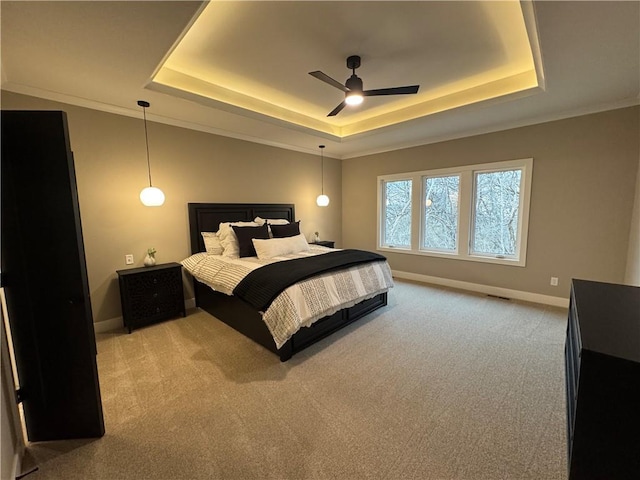 bedroom featuring ceiling fan, a raised ceiling, baseboards, and light carpet