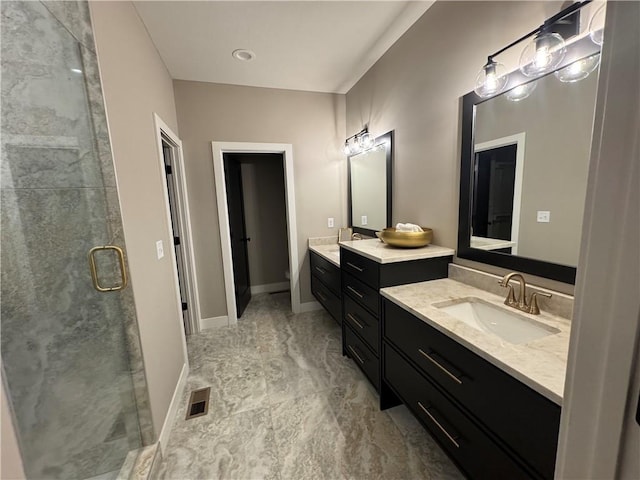 full bath with visible vents, two vanities, a sink, a shower stall, and marble finish floor