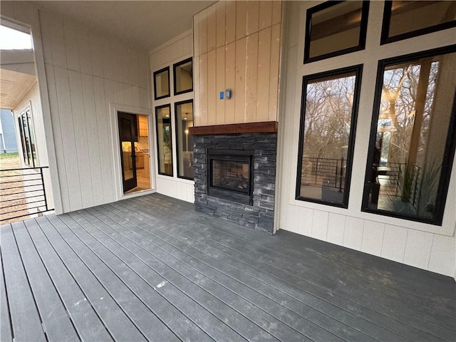 wooden deck featuring an outdoor stone fireplace