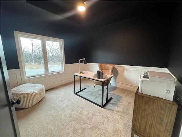 home office featuring a wainscoted wall, visible vents, and light carpet