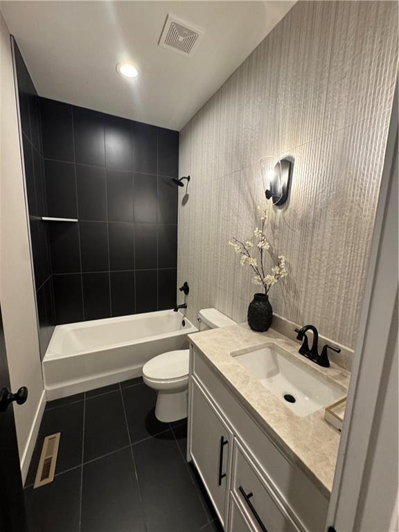 bathroom featuring shower / bathing tub combination, visible vents, toilet, and tile patterned flooring