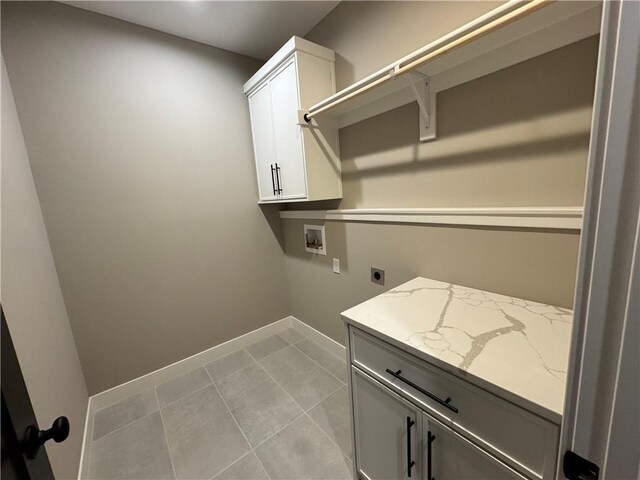 washroom featuring baseboards, light tile patterned floors, hookup for a washing machine, cabinet space, and electric dryer hookup