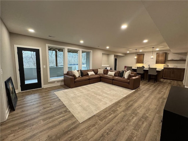 living room with recessed lighting, baseboards, and dark wood-style floors