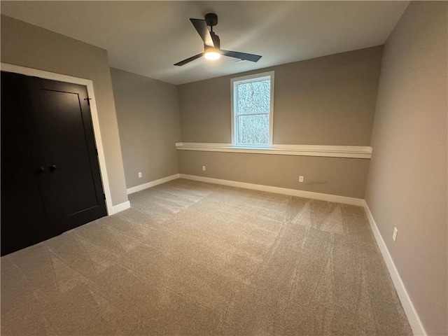 unfurnished room with baseboards, carpet floors, and a ceiling fan