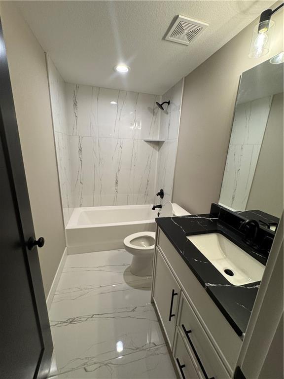 bathroom featuring visible vents, toilet, marble finish floor, a textured ceiling, and shower / bath combination