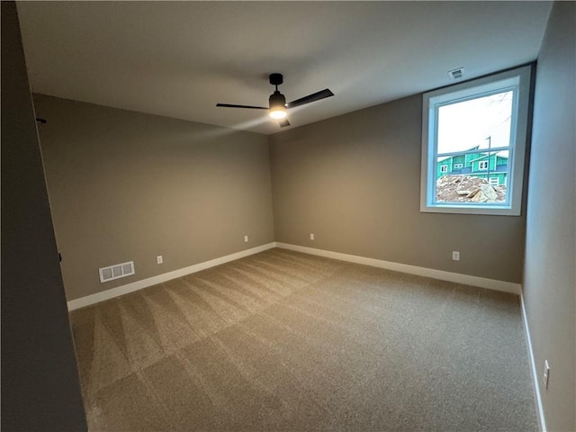 spare room featuring visible vents, baseboards, carpet, and a ceiling fan