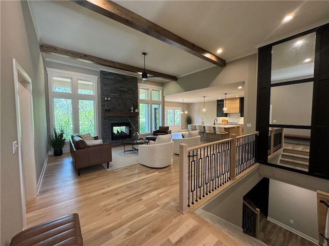 living room with a multi sided fireplace, baseboards, beamed ceiling, light wood-style floors, and recessed lighting