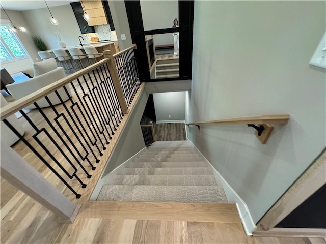 stairway featuring baseboards and wood finished floors