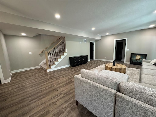 living area featuring baseboards, dark wood finished floors, stairs, and visible vents