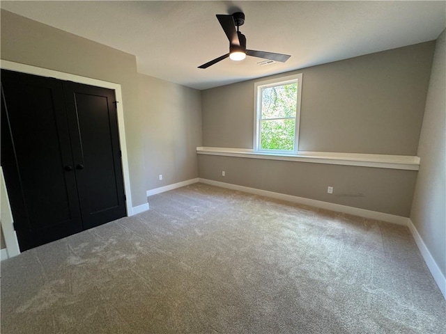 unfurnished bedroom featuring baseboards, light carpet, a ceiling fan, and visible vents