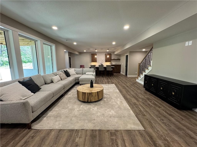 living room with recessed lighting, baseboards, stairway, and dark wood-type flooring