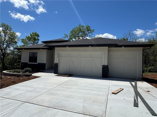 view of front of home with an attached garage, driveway, and stucco siding