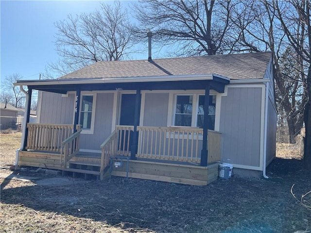 view of front of property with a porch and roof with shingles