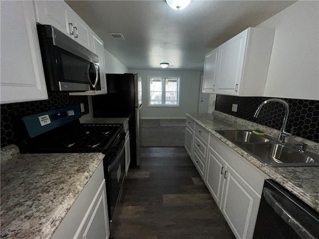 kitchen with dishwashing machine, a sink, white cabinets, black range with gas cooktop, and stainless steel microwave